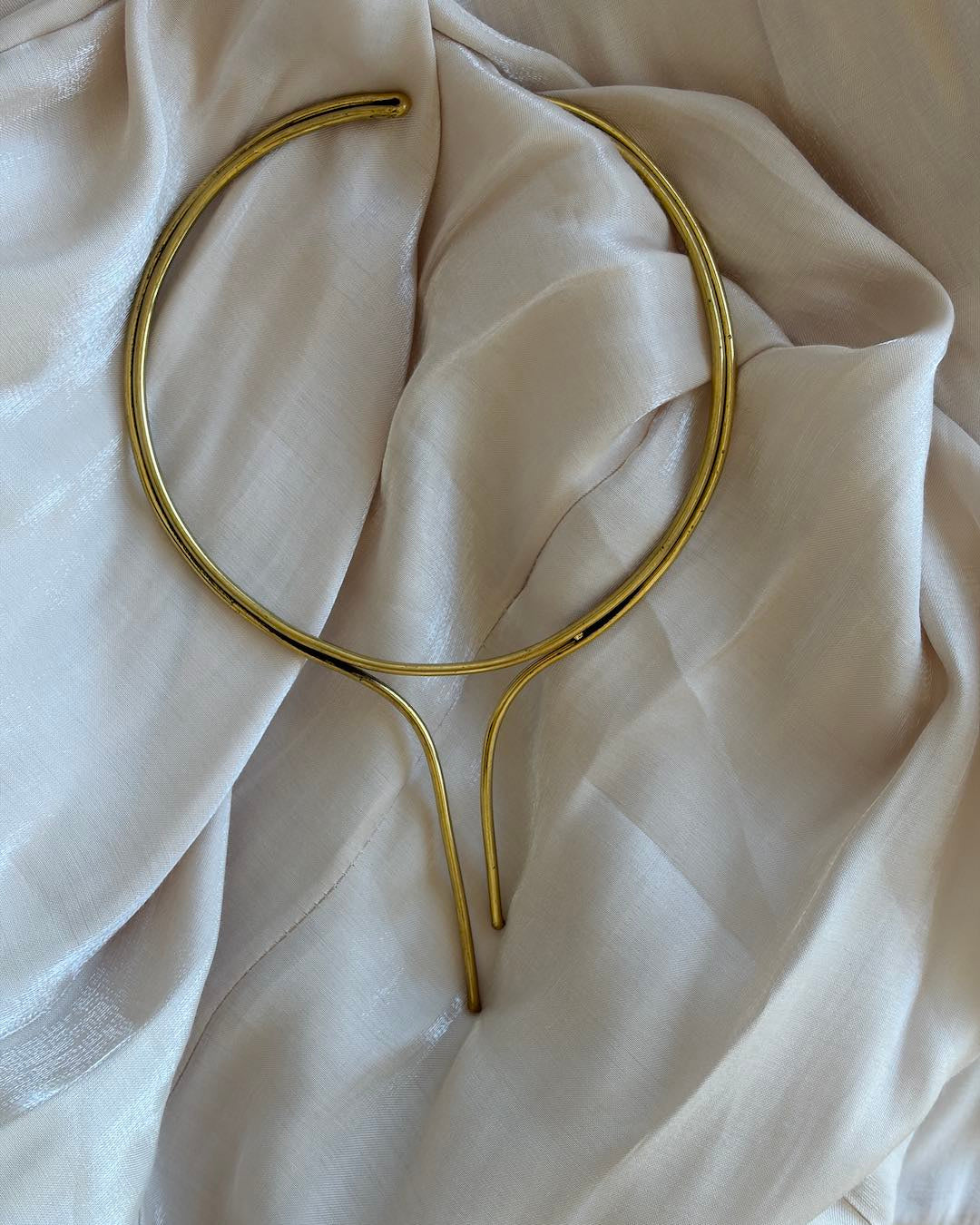 Gold necklace on a beige fabric background