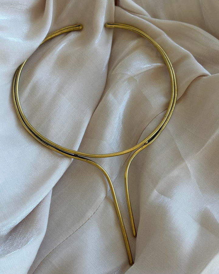 Gold necklace on a soft beige fabric background