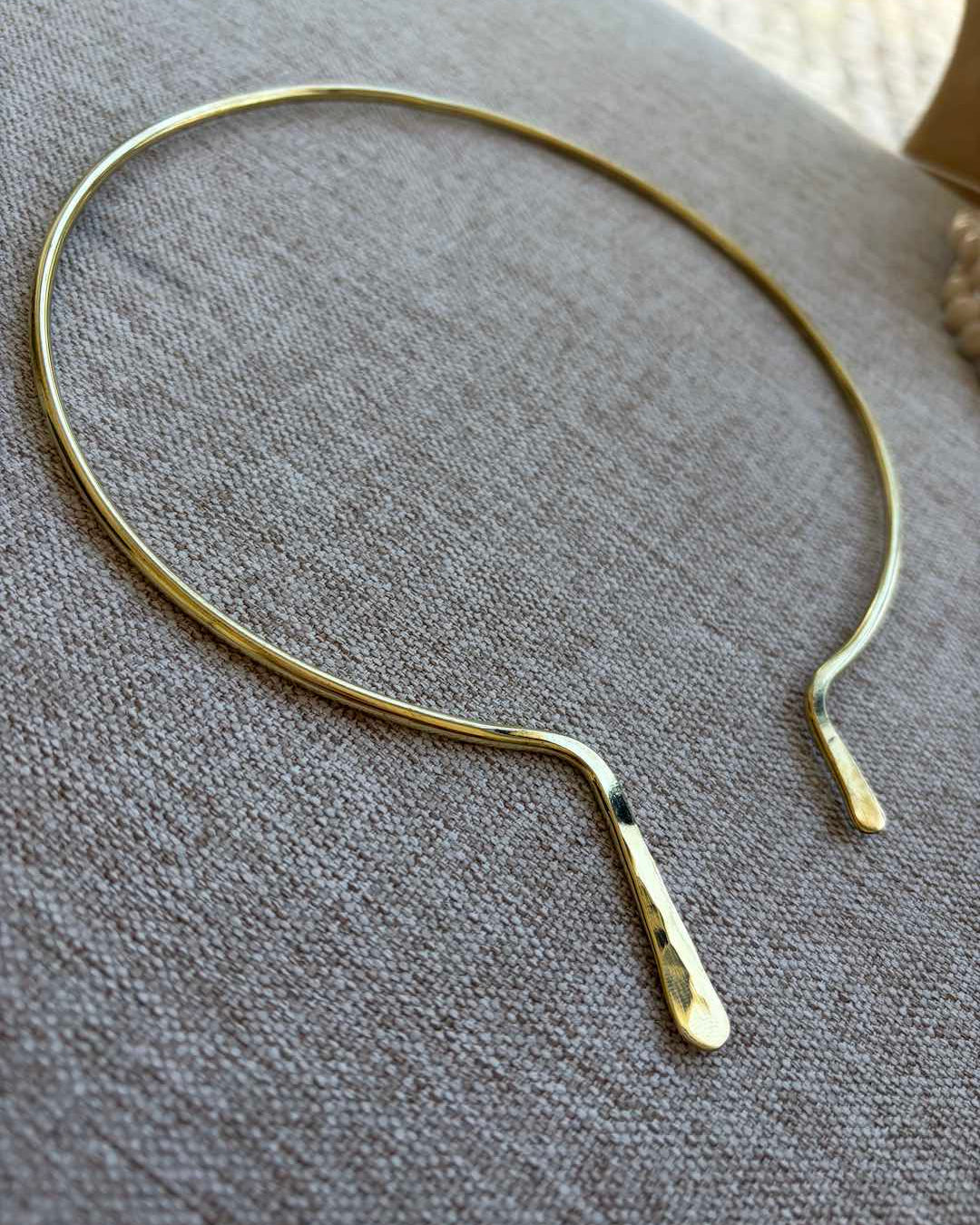 Gold necklace on a textured gray surface