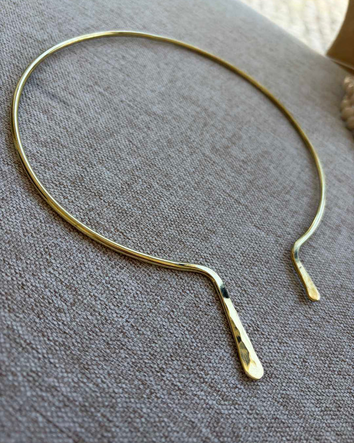 Gold necklace on a textured gray surface