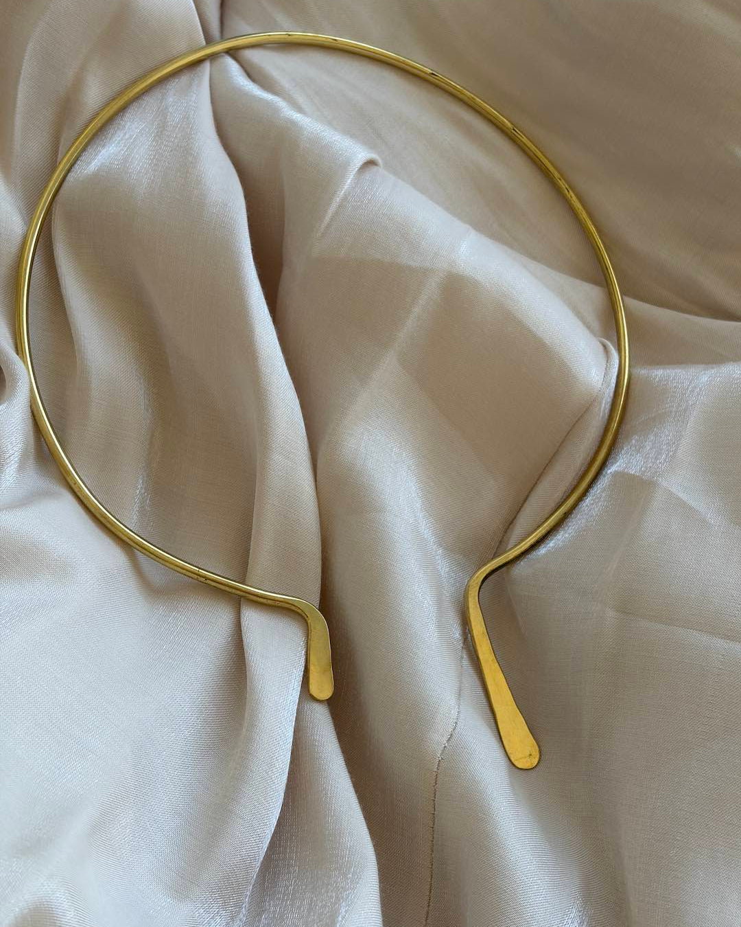 Gold necklace on a beige fabric background