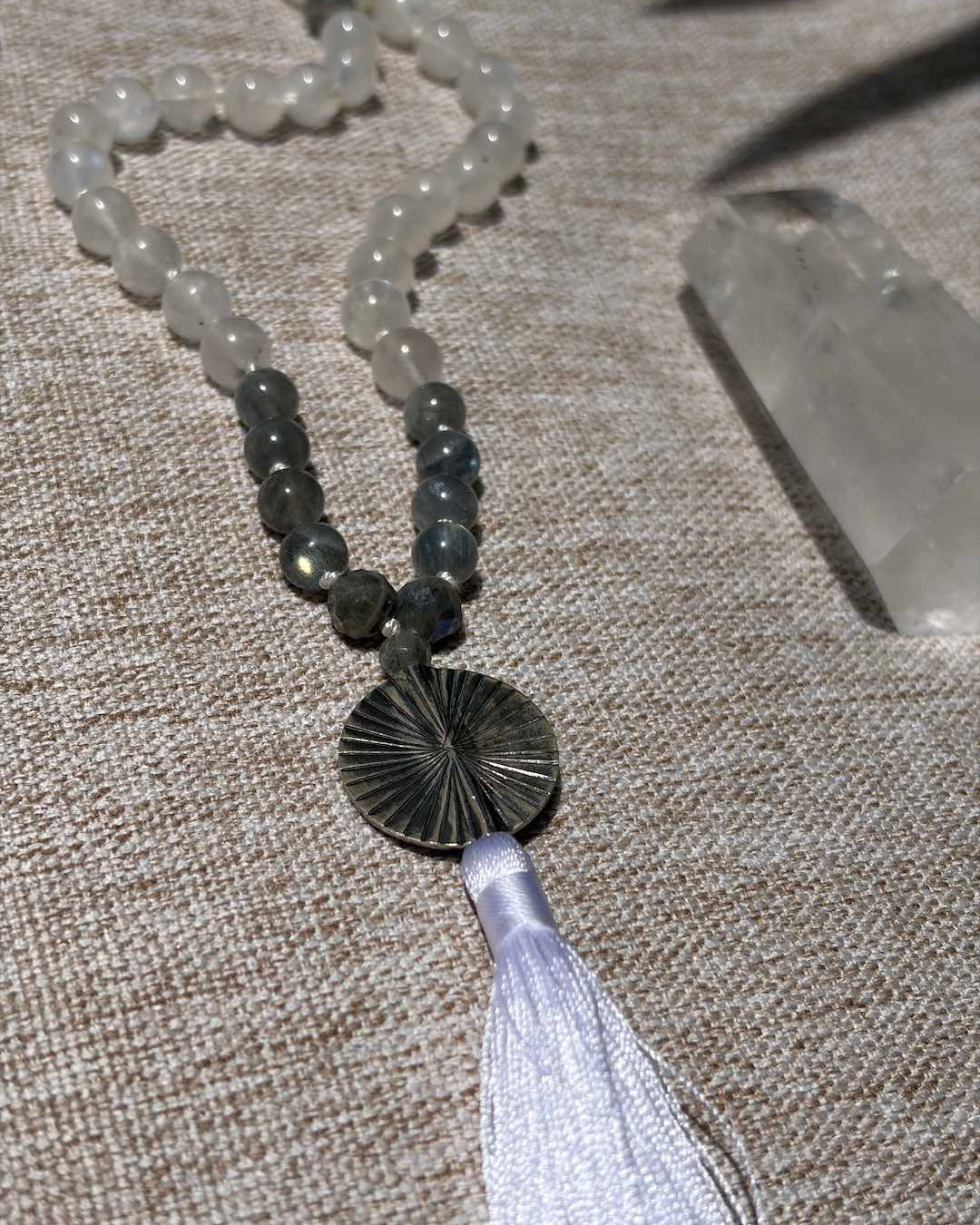Necklace with beads and tassel on a textured surface