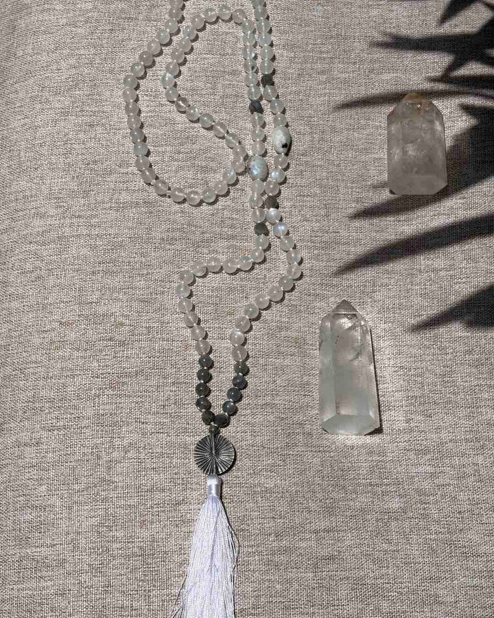 Necklace with beads and tassel on a textured surface