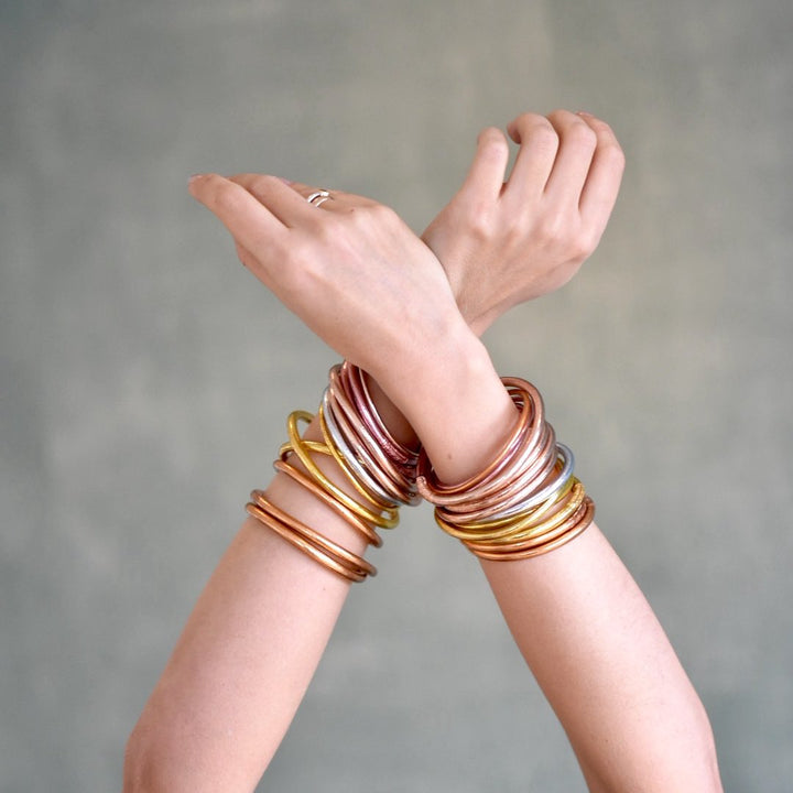 Lady wearing a mix of Gold leaf Temple Buddhist Bangles with Love and Lack Mantra