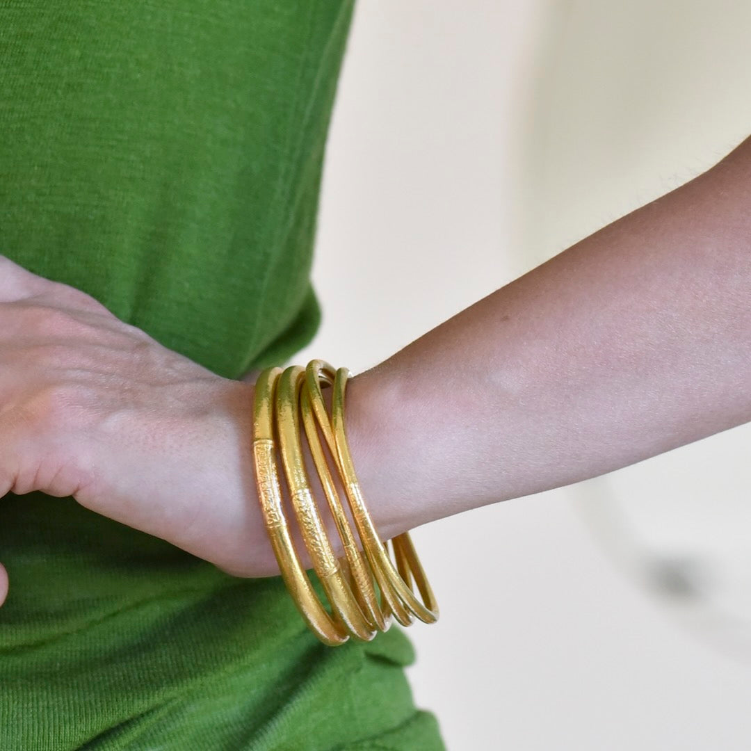 Lady wearing a set of thin and thick Buddha gold leaf temple bangles with mantra